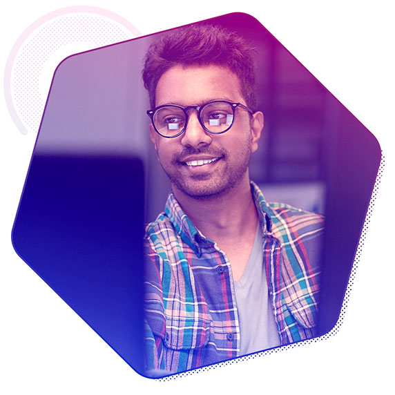 Man wearing glasses and smiling looking at a screen.